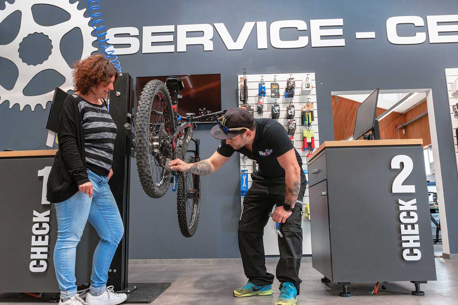 Mitarbeiter inspiziert Fahrrad von einem Kunden